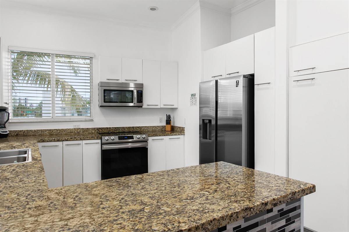 Well-equipped kitchen with breakfast counter and natural light from windows