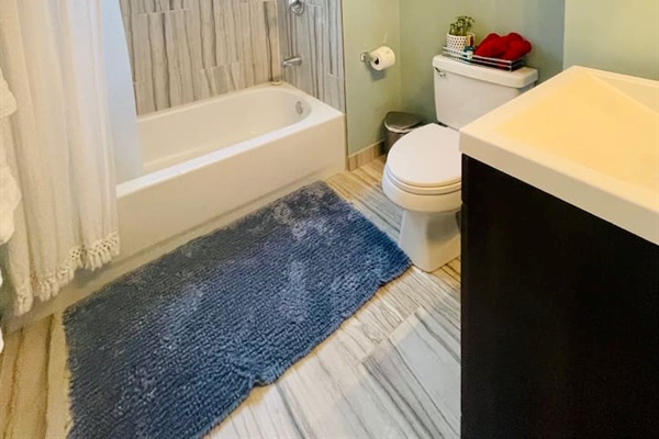 Bathroom with full bathtub and fully stocked