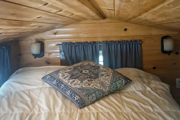 A comfy queen bed is in the loft! Access is a steep staircase made of shelves. Not recommended for those with mobility issues. 