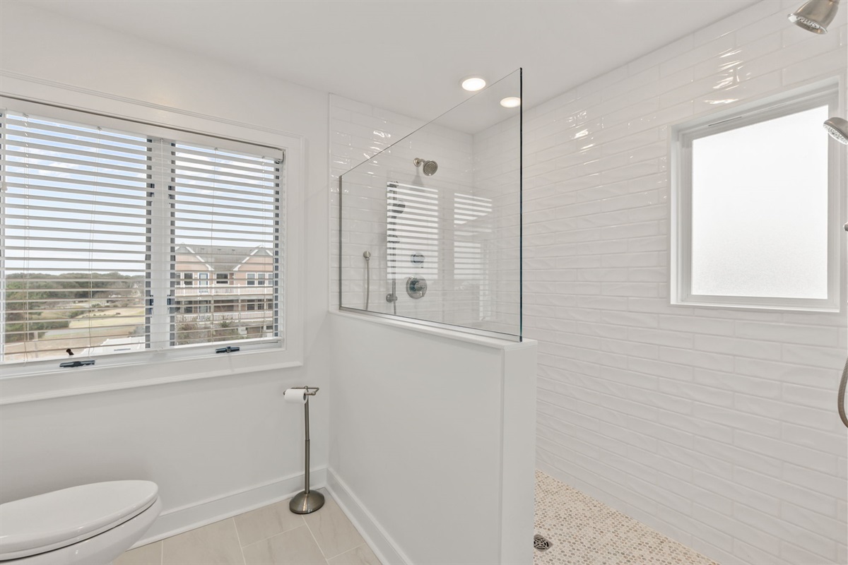 Full bathroom with a glass walk-in shower and natural light.