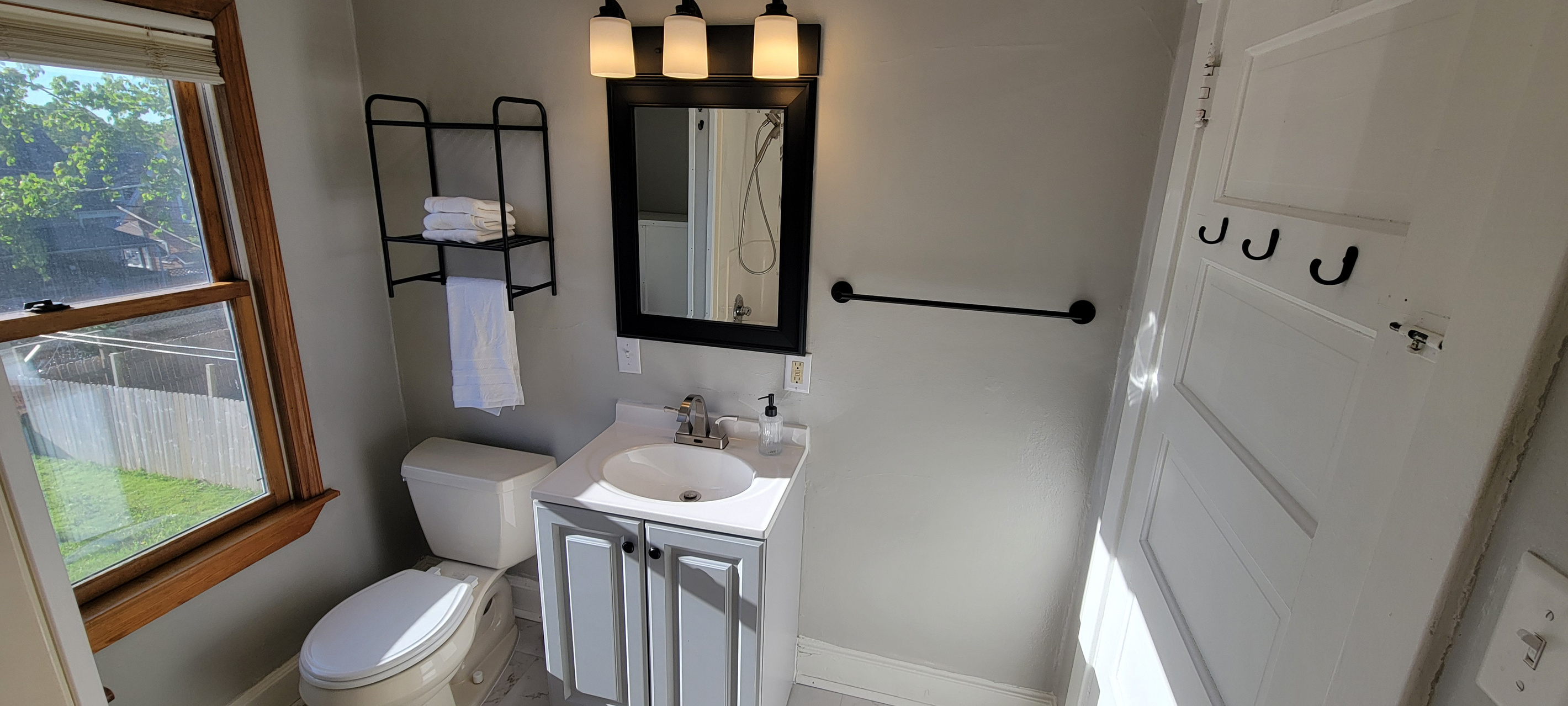 Clean bathroom with fresh towels, sink, mirror, and toilet.