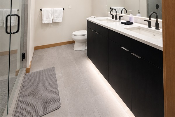 Spa-inspired bathroom featuring a dual-sink vanity, quartz countertops, matte black fixtures.
