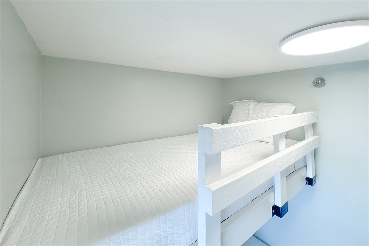 Versatile bunk bedroom offering comfortable accommodations for guests or family. This space maximizes functionality and style, providing a cozy and inviting atmosphere.