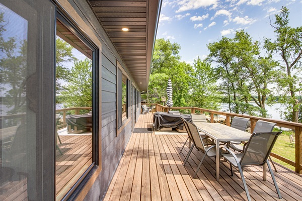 Spacious upper deck with outdoor dining and lounge seating overlooking the lake