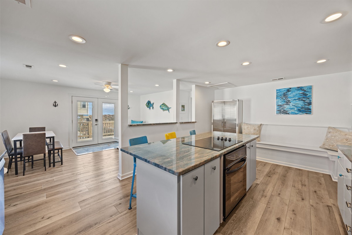 Large, well-equipped kitchen with island seating and open sightlines to the living and dining areas