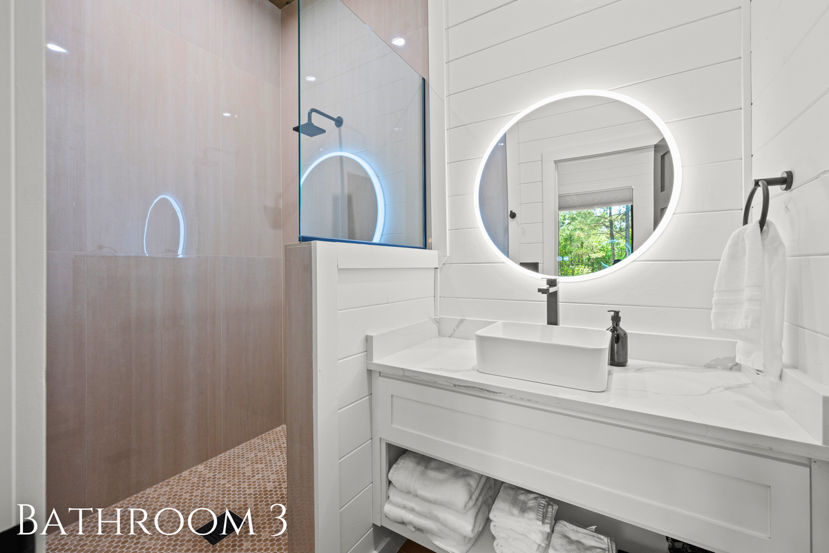 Clean modern finishes, warm lighting, and plenty of space continue throughout this beautifully styled bathroom, creating a comfortable and refreshing experience.