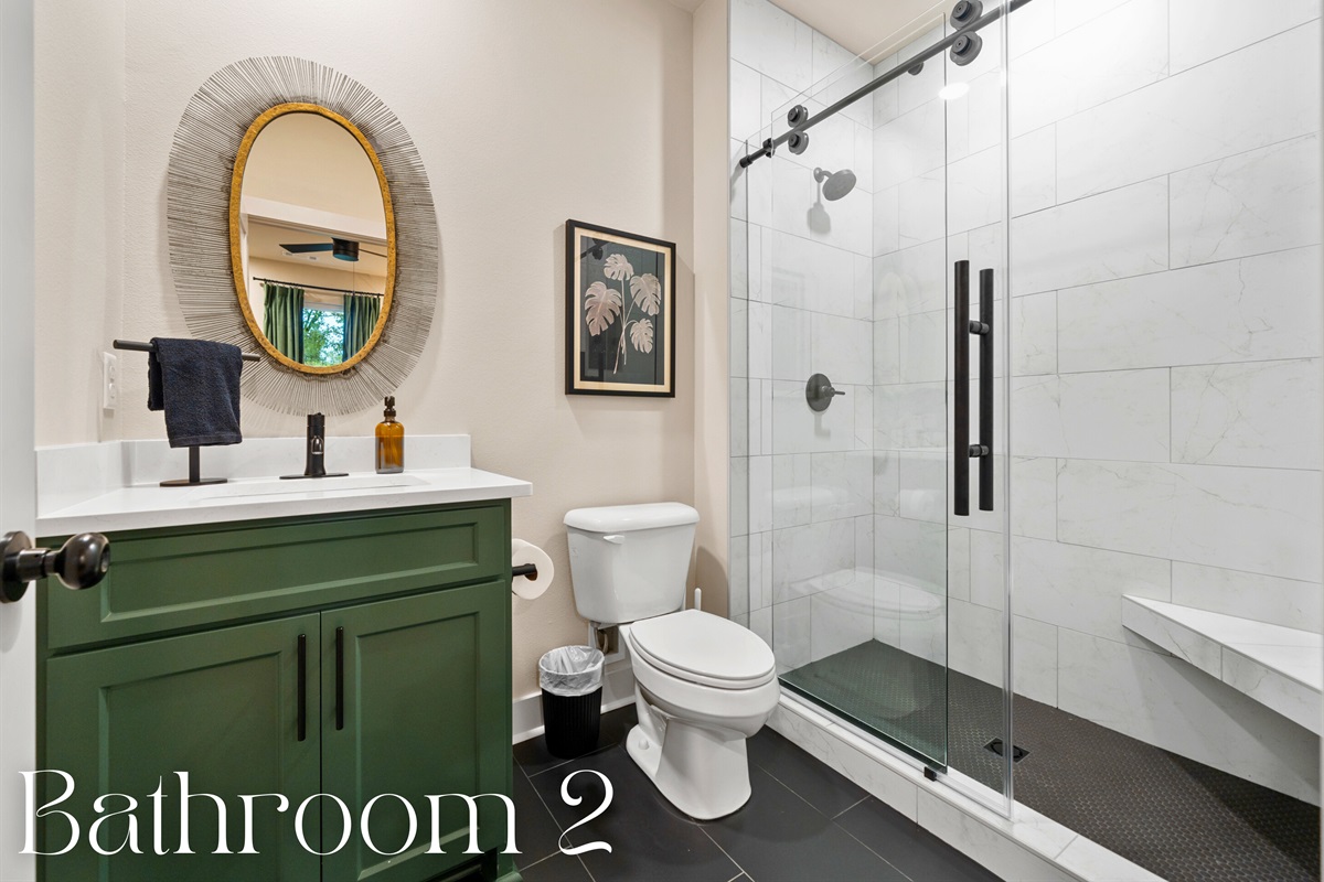 This stylish bathroom showcases a vibrant green vanity paired with elegant gold fixtures, creating a striking visual contrast.