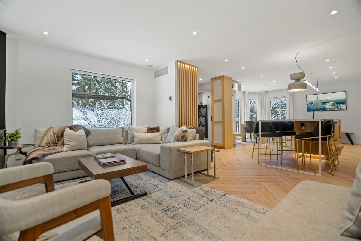 Living room evolves into kitchen and dining in this wonderfully bright and adaptively designed main floor space