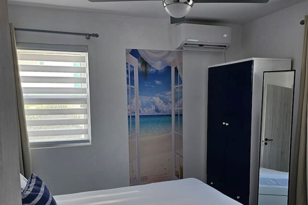 Queen size bed, new mattress, full length mirror, darkening curtains, A/C, ceiling fan, and wardrobe