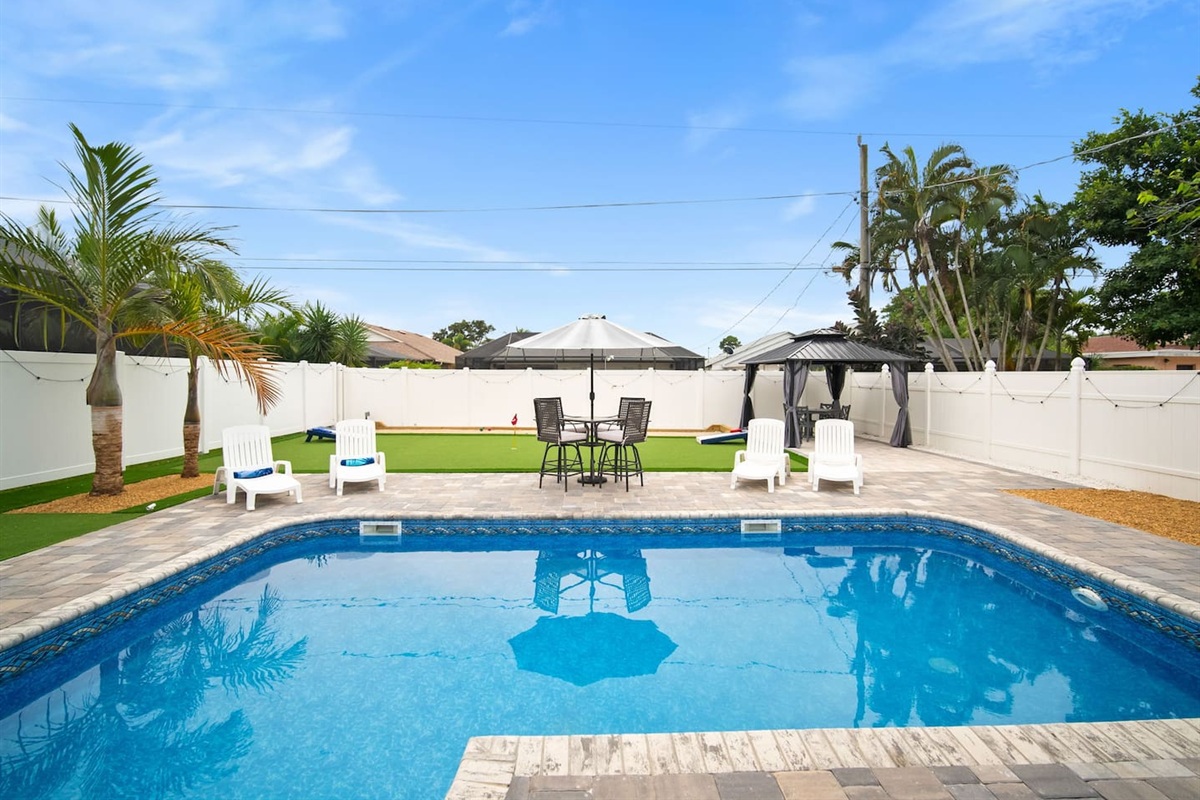 Pool, lounge chairs, and the gazebo in the back with the ceiling fan
