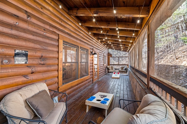 Back screened in porch with hot tub and cornhole