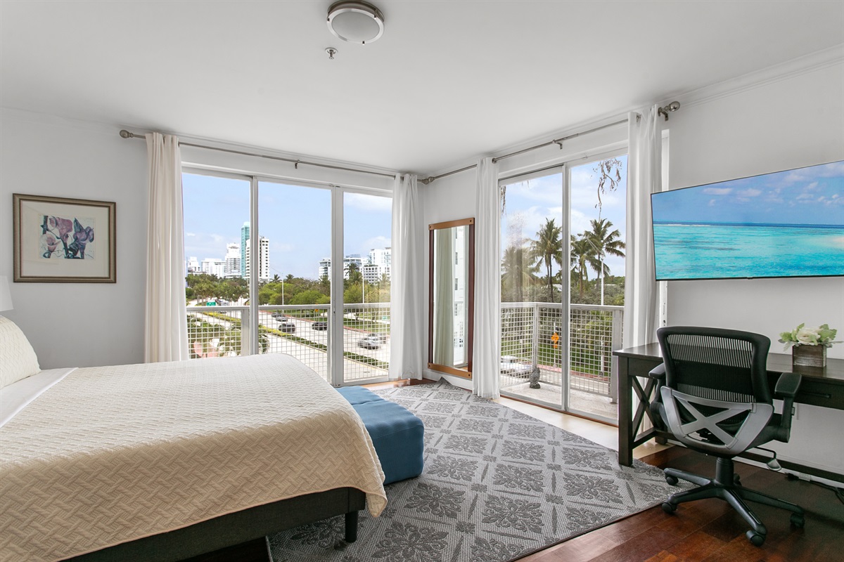 Very private corner Primary Suite with desk, walk-in closet, en-suite bath, and a balcony with city and waterway views