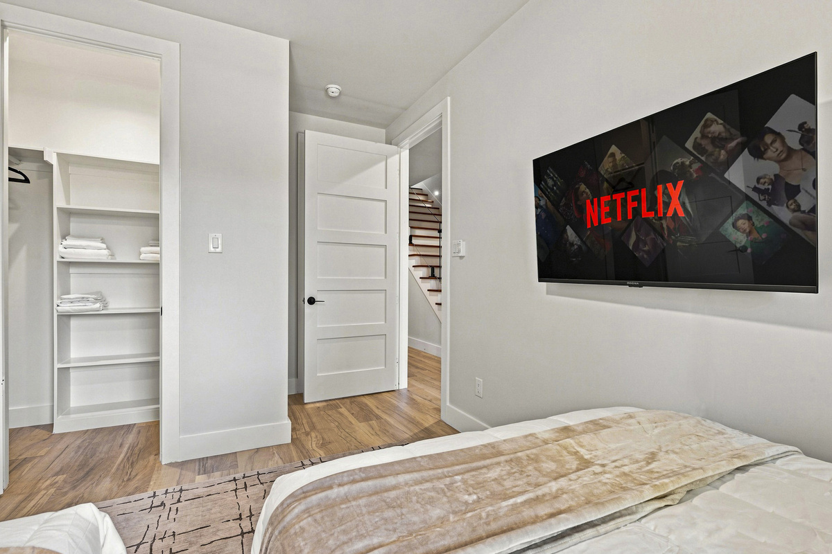 Enjoy movie nights in style with a sleek TV and plush bedding!
