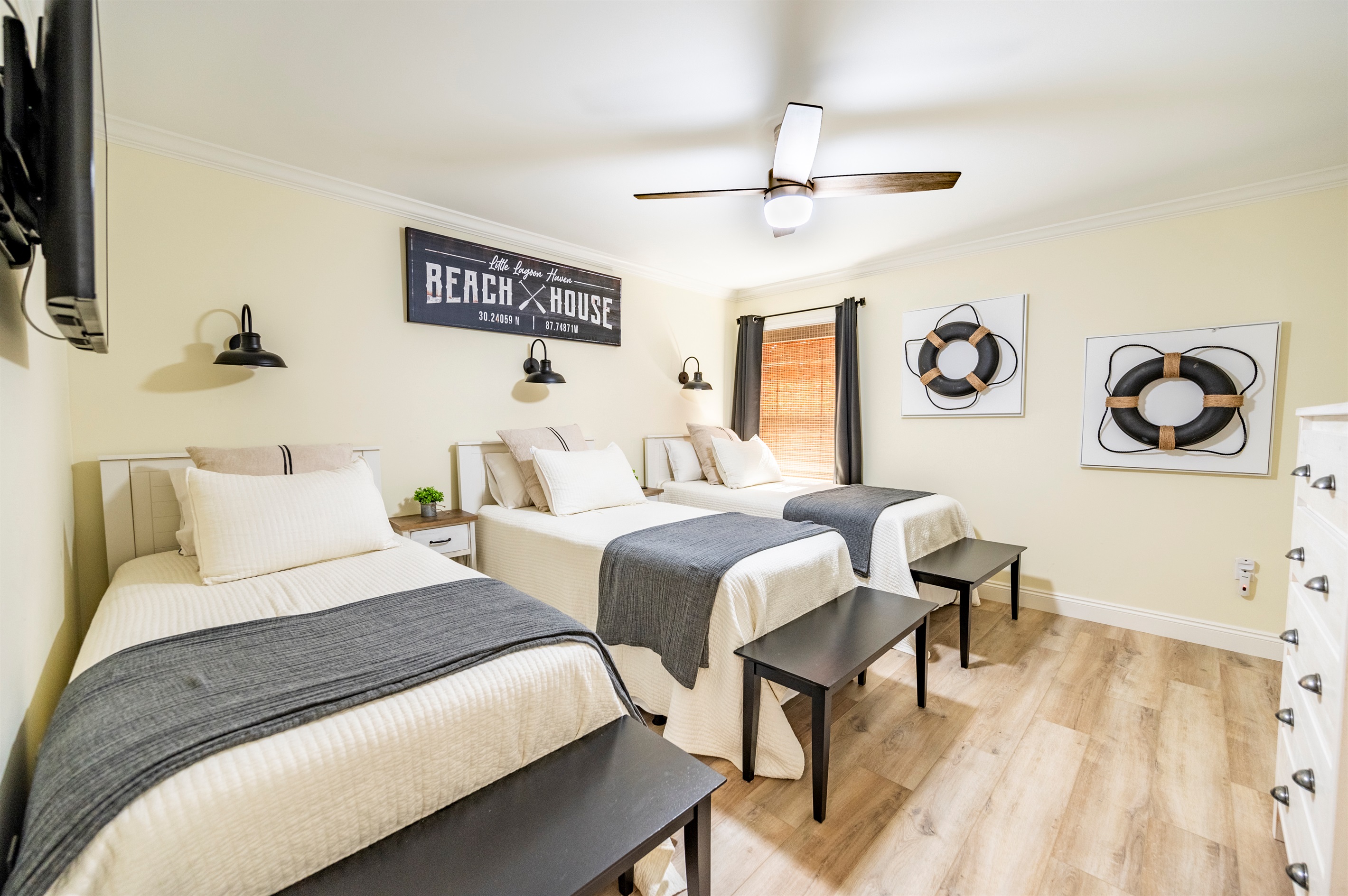 Cozy beach house bedroom with three comfy beds and coastal-inspired decor.