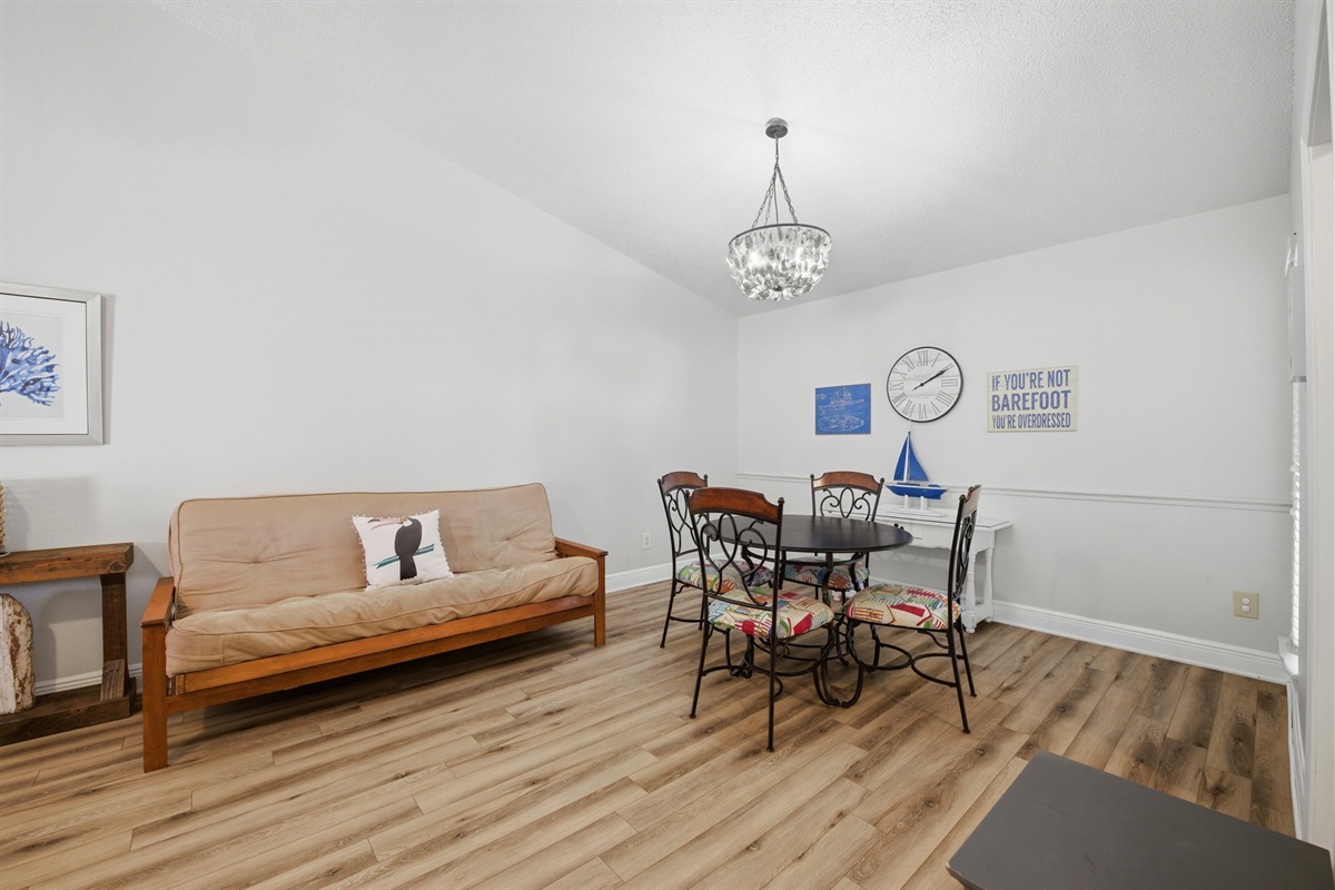 The dining room provides plenty of open space with natural light and coastal-inspired décor. With a stylish round table and cozy seating nearby, it’s an inviting place to enjoy meals, conversation, and time with family or friends.
