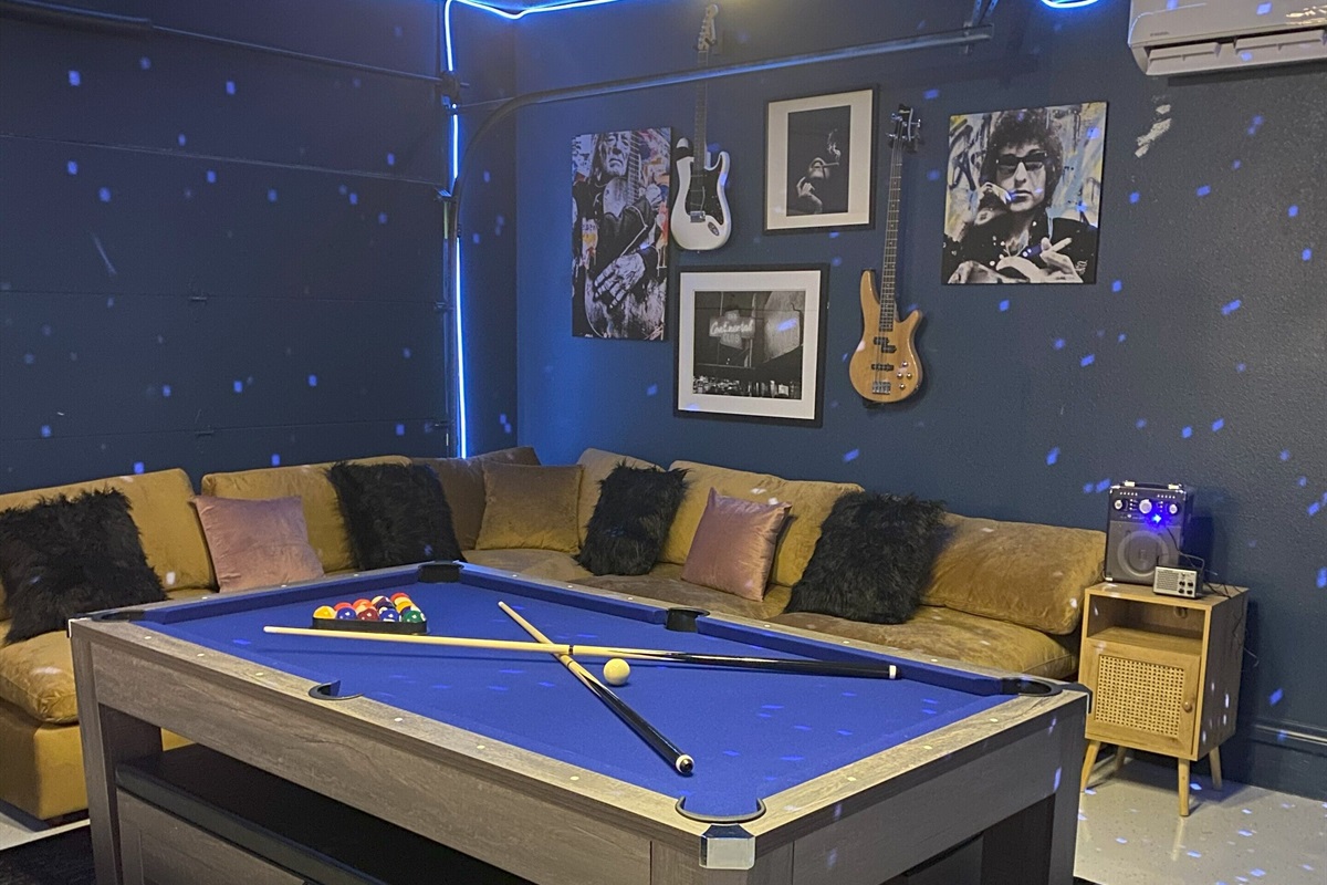 Welcome to your exclusive & modern speakeasy! Indulge in luxury with a sleek pool table, neon-lit bar, and vintage arcade games. Enjoy your favorite drink under a canopy of ambient lights. Perfect for a night of fun and relaxation in true style.