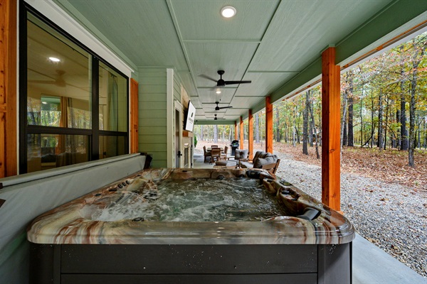 Covered outdoor hot tub with bubbling jets and forest views—perfect for relaxing during your Broken Bow getaway