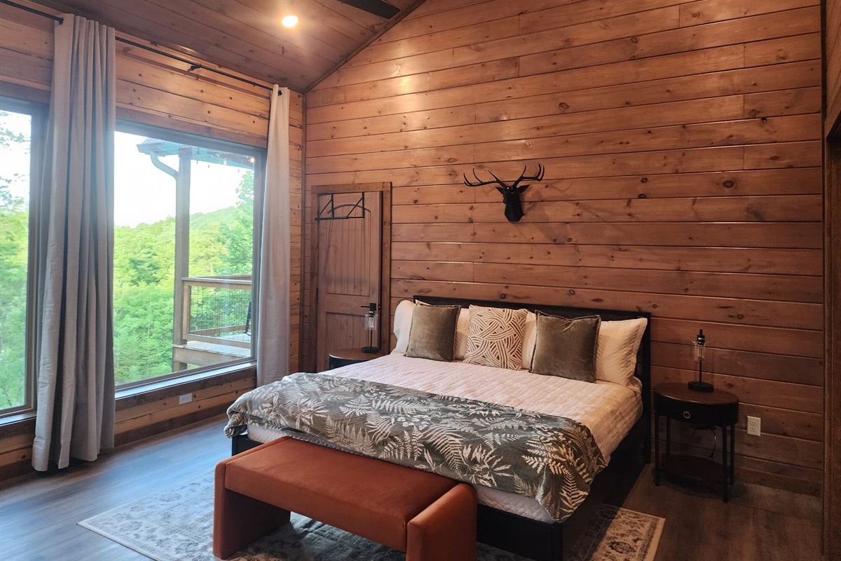 Bedroom with king bed, wood paneling, and cozy decor