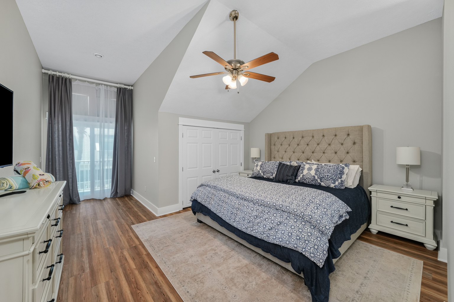 Primary King bedroom with plush linens,, stylish coastal décor, ceiling fan, and natural light and En suite bathroom