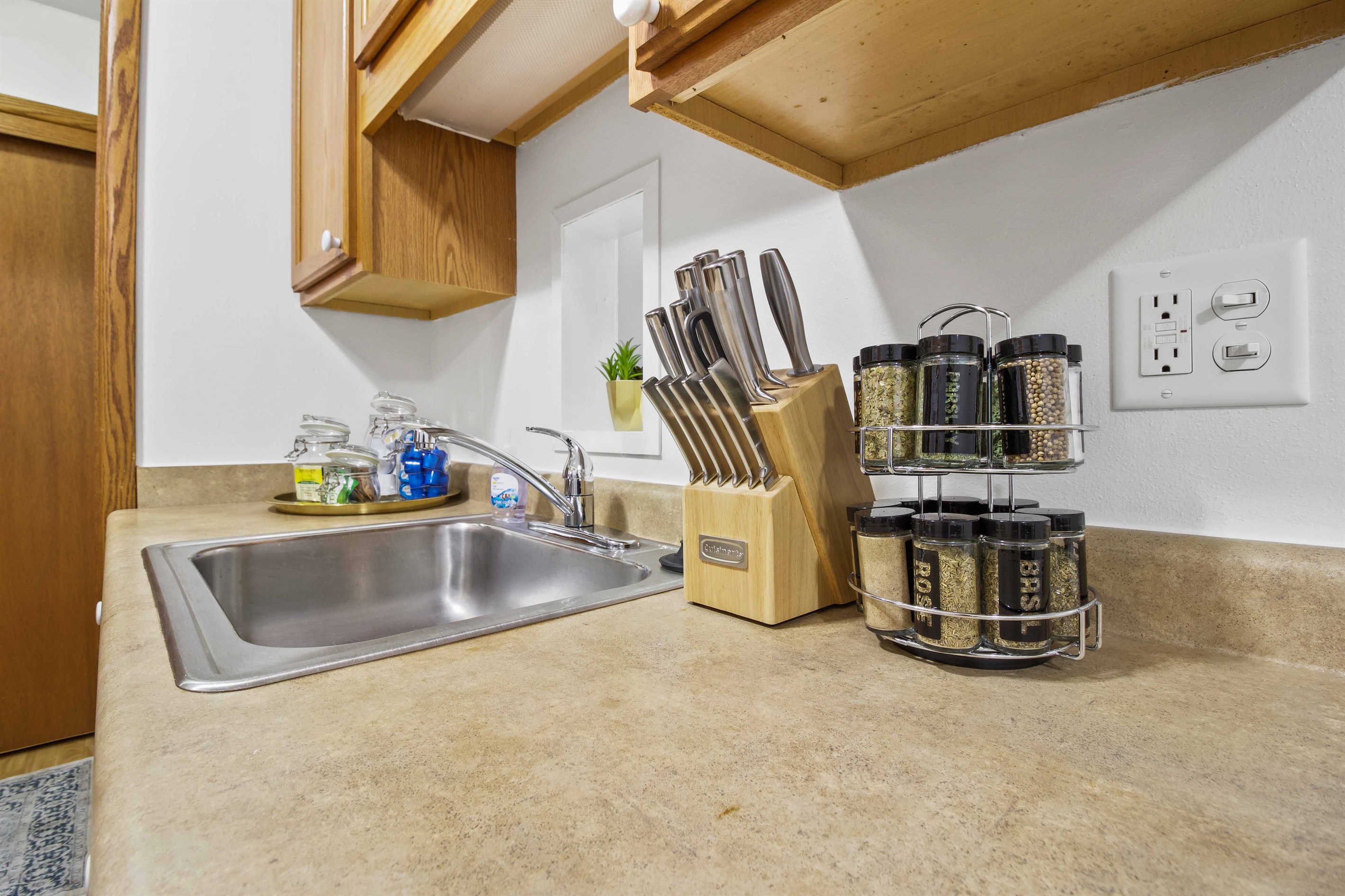 Knife block, spice rack, coffee, creamer, sugar and tea.