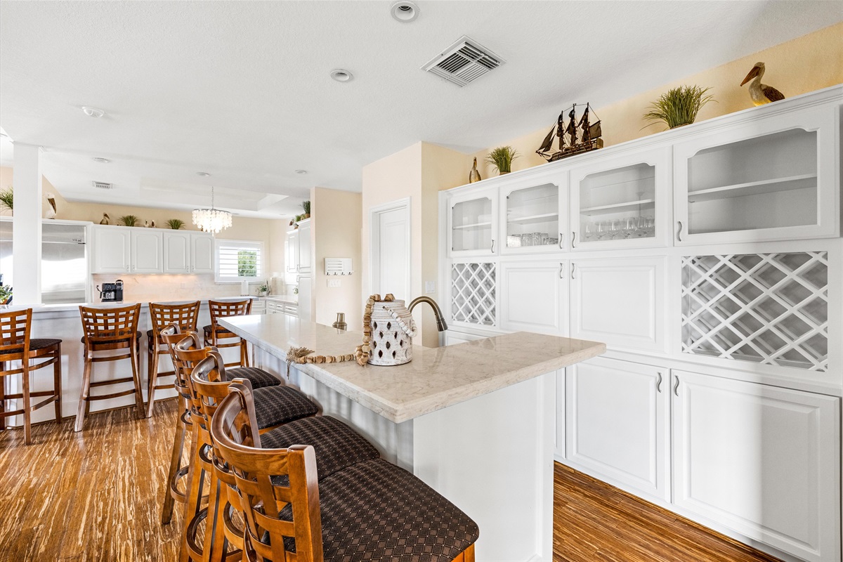 Kitchen Paradise: Sleek countertops and elegant seating await your culinary adventures while mixing a drink at the wet bar!