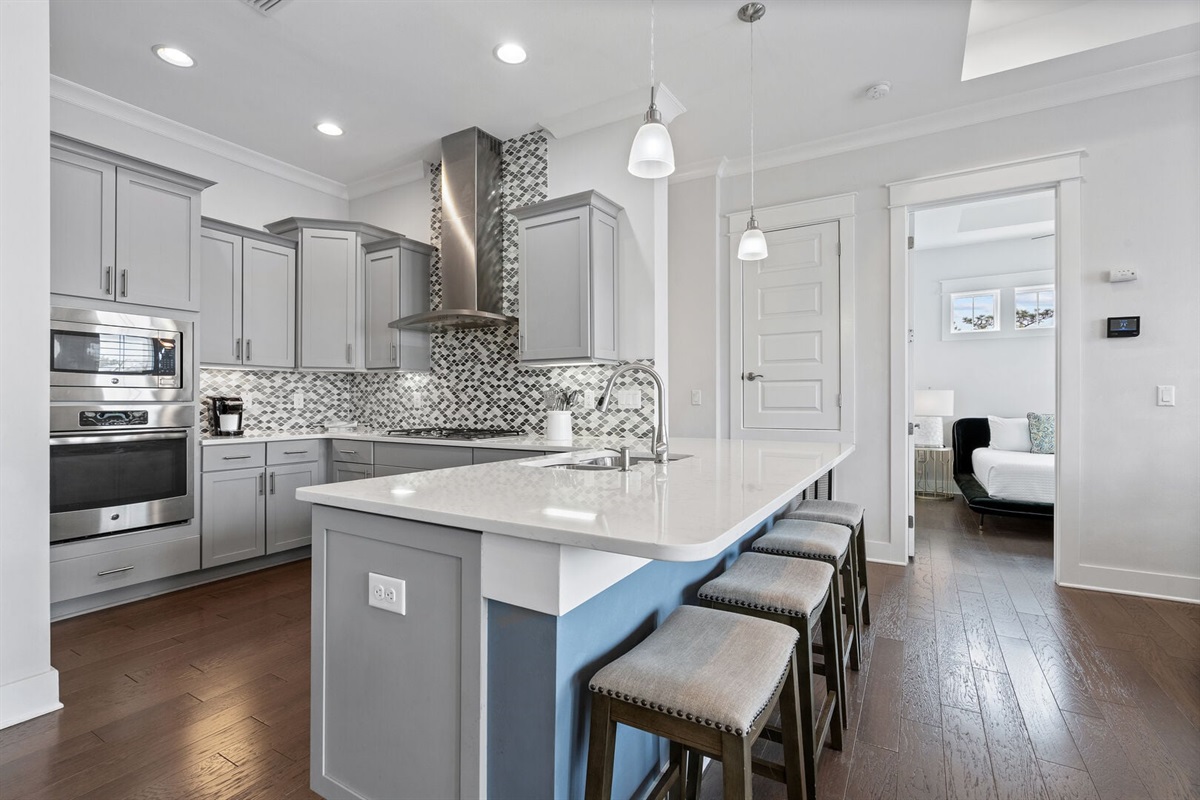 Designer mosaic backsplash and stainless vent hood.