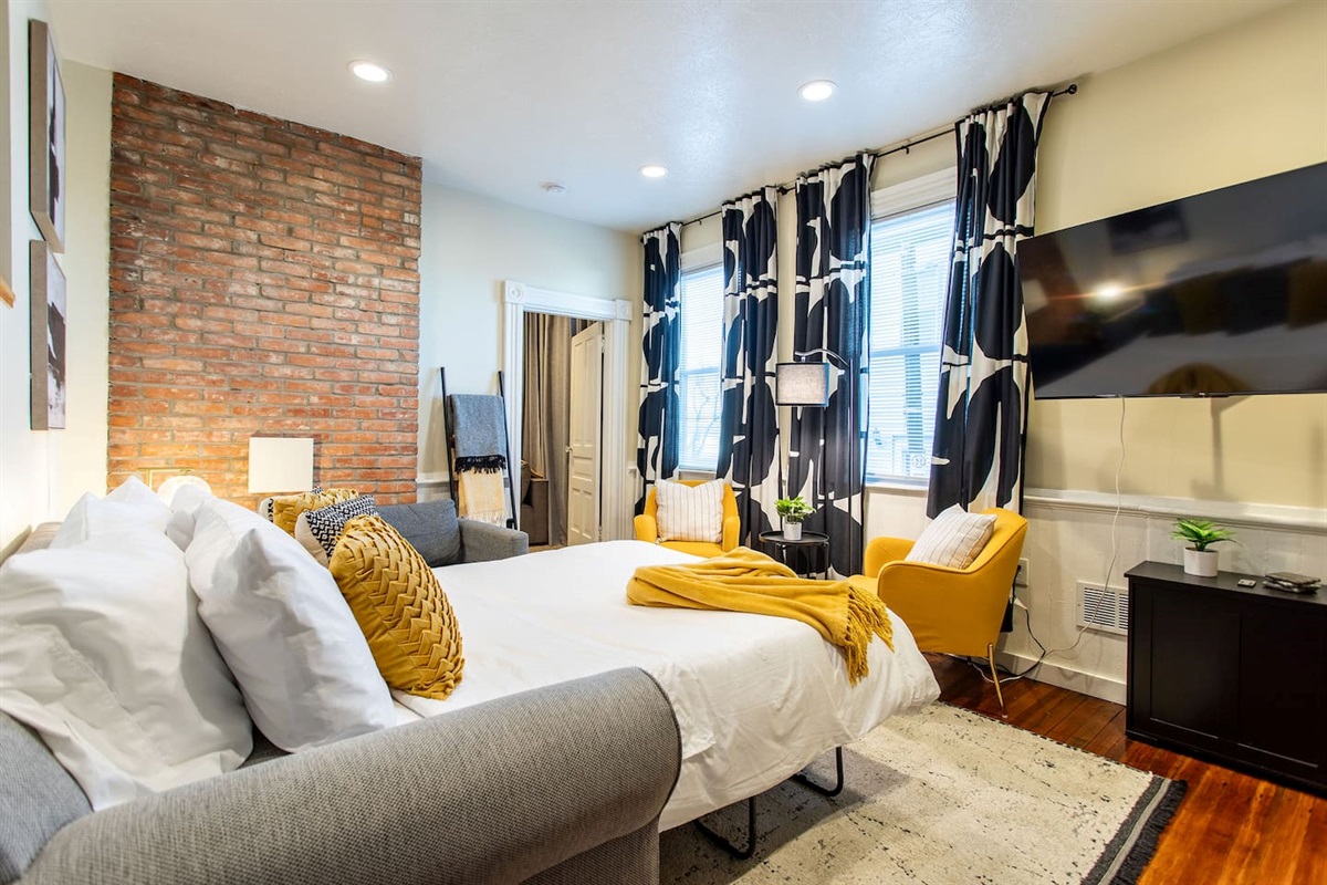 A warm and inviting living area featuring a plush sofa, soft lighting, and a dedicated workspace with a sleek desk and comfortable chair, perfect for productivity and relaxation.