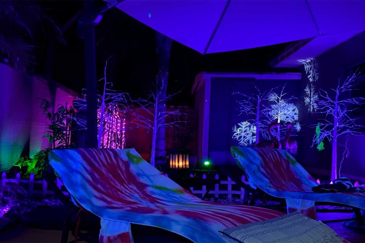 Poolside lounge seating at Garden of Manors, softly illuminated at night, offering a relaxed space to unwind under the stars in a private tropical setting.