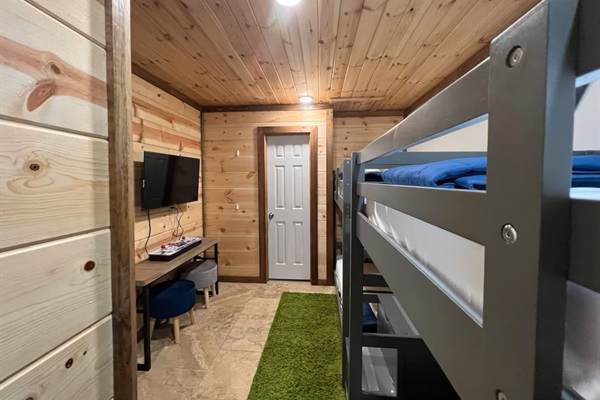 Bunk space with retro arcade TV and private bath—great for downtime.