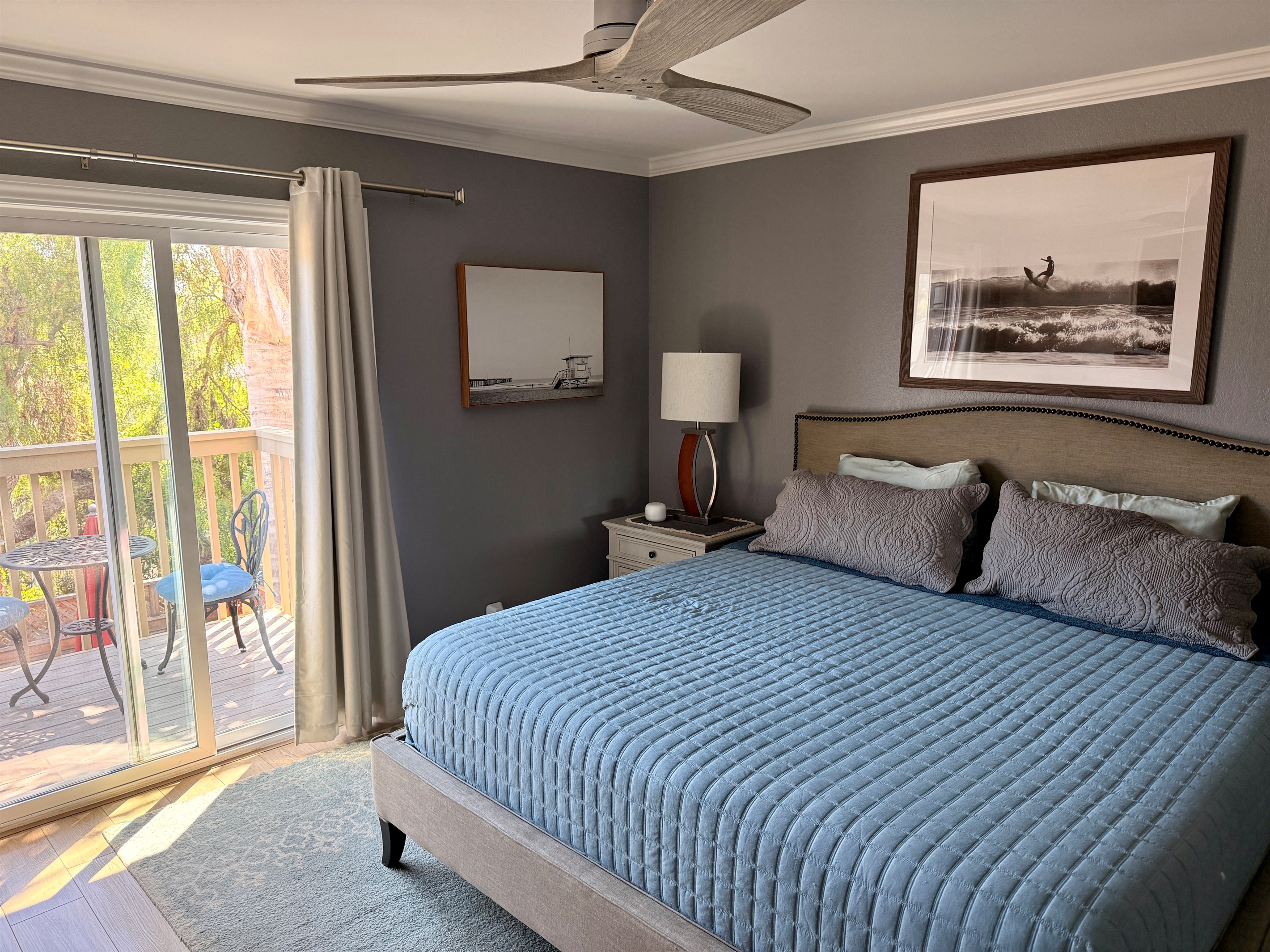Primary bedroom with sliding door to balcony overlooking the yard and mountains.