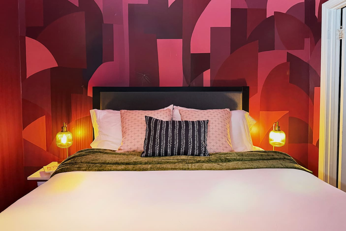 The principal (queen) bedroom with en suite bathroom doesn't whisper — it announces itself. Bold murals, warm vintage lighting & boutique-hotel energy. Minutes from the Quarter, but this room might be the destination.