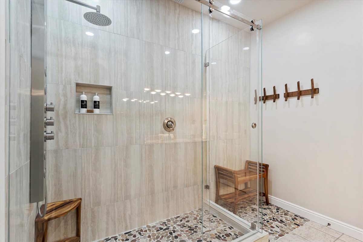 Enjoy a spa-like experience in this oversized walk-in shower featuring dual showerheads and elegant tile finishes.