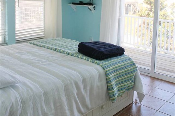 2nd floor guest bedroom #2, back of house. Balcony access. Queen bed. TV. Dresser for clothes storage.