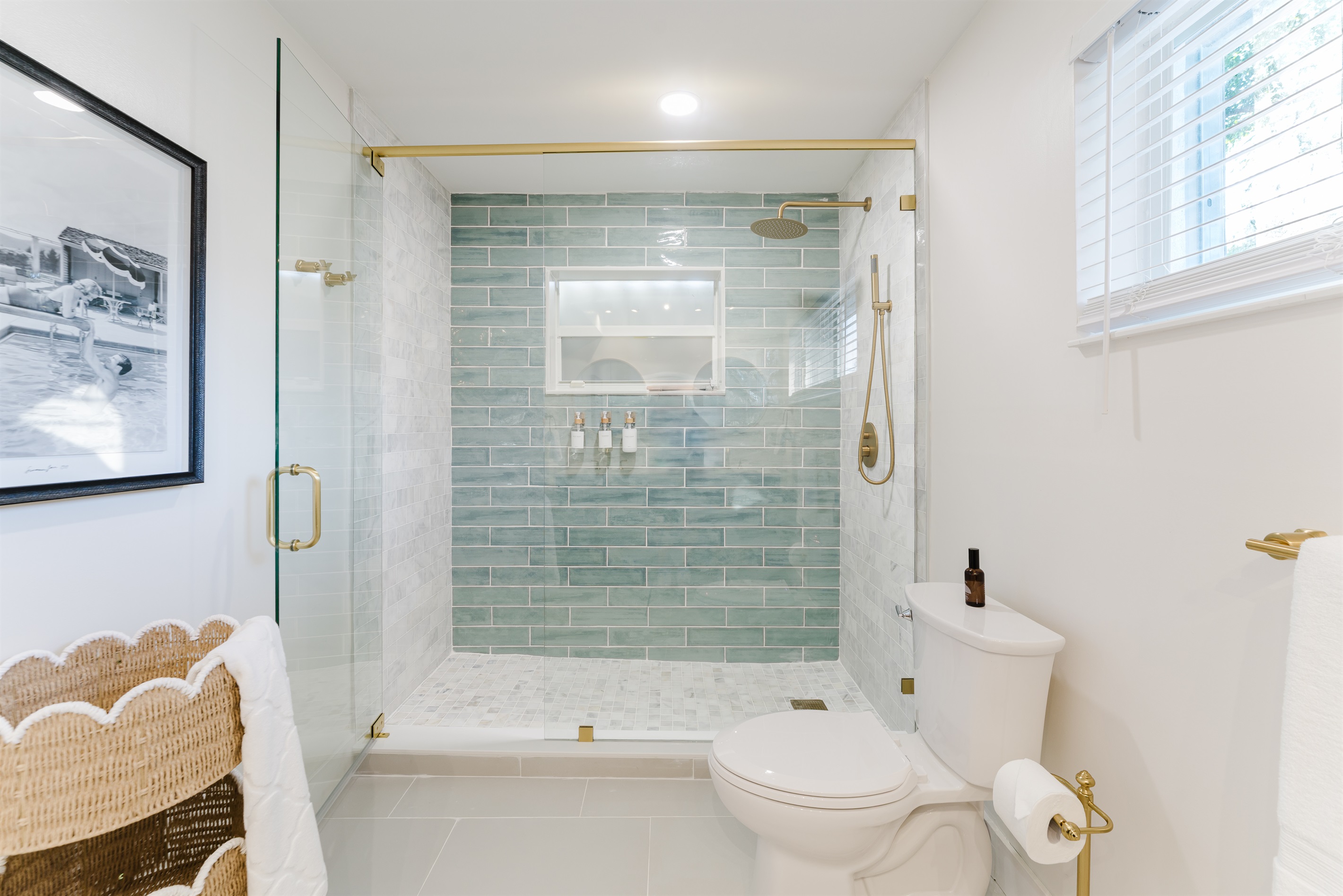 Spa-inspired ensuite with a walk-in glass shower, soft sage tile, and brushed brass fixtures. A double vanity with designer mirrors creates a bright, hotel-style retreat made for slow mornings and effortless luxury.