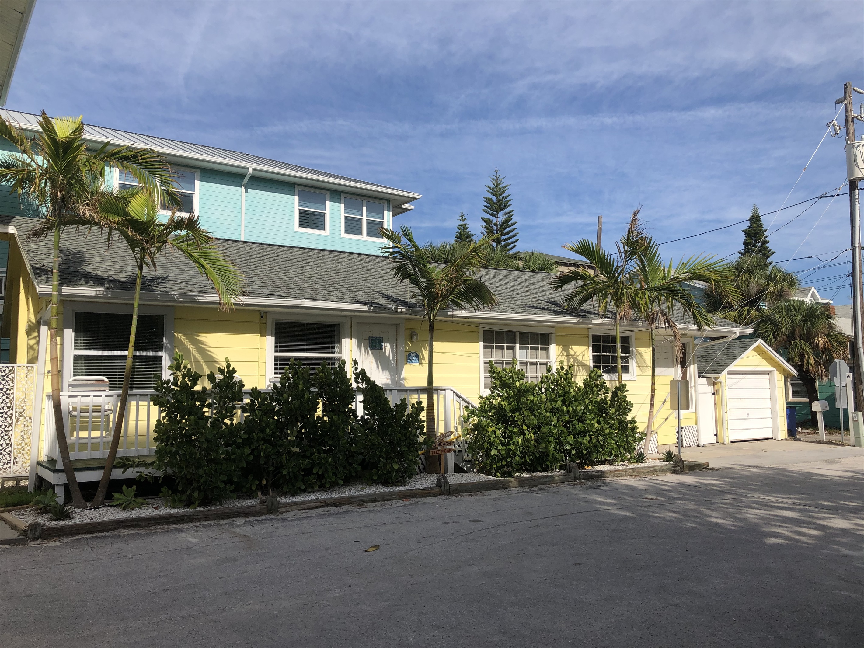 Palm trees and front deck of the private house just 50 feet from the beach!
