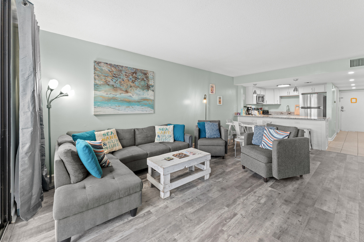 Comfy living room area with large TV and balcony access
