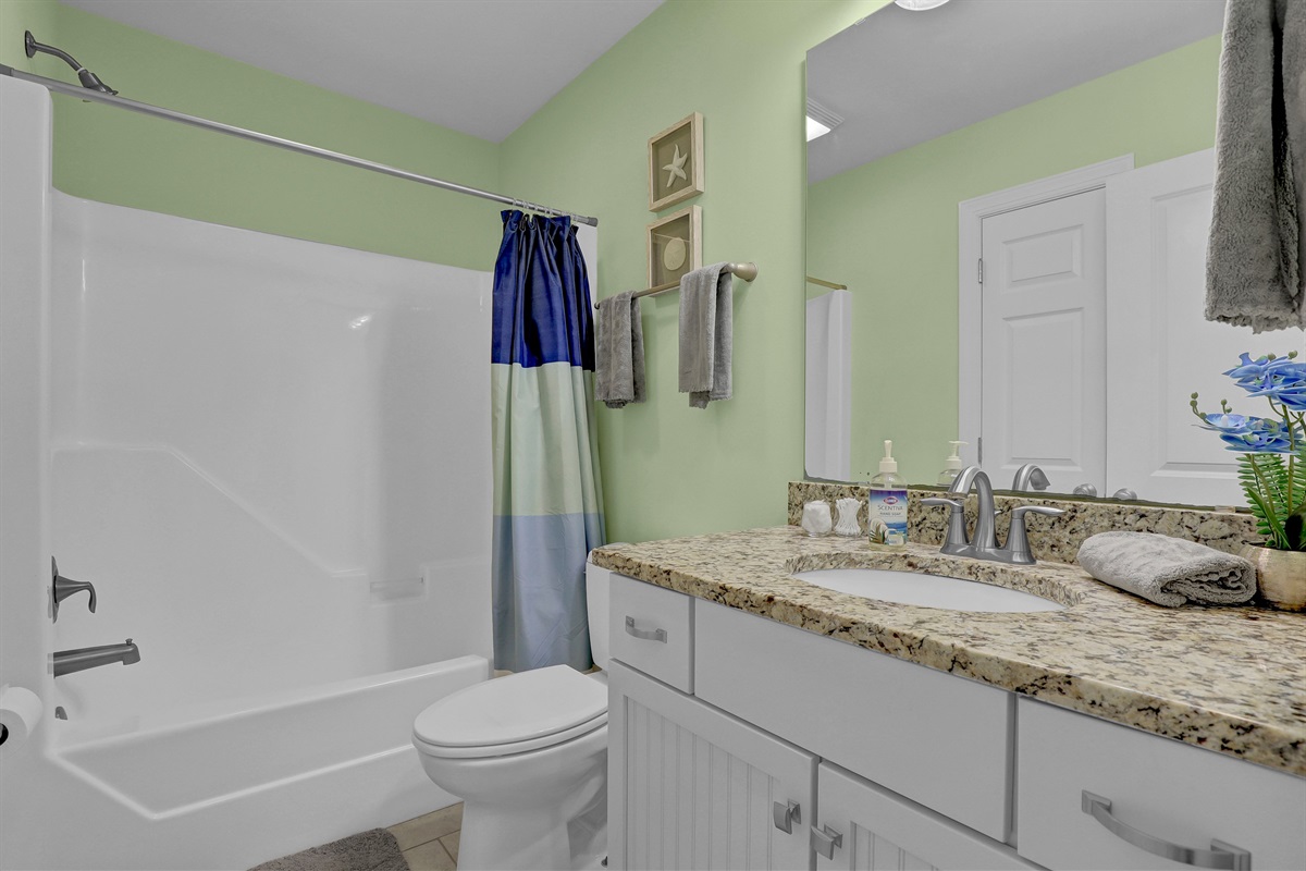 Clean and modern full bathroom with granite countertops and fresh finishes.