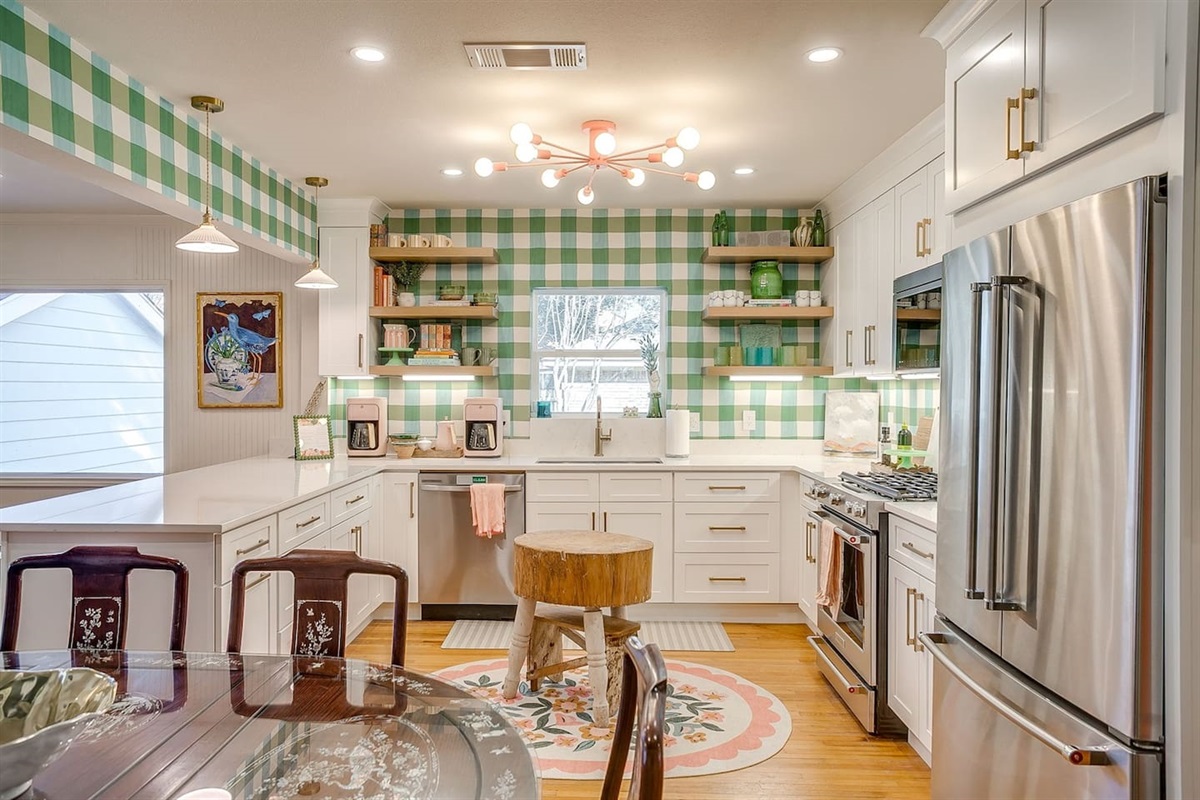 A kitchen designed for gathering, generous drawer storage, open floating shelves, and a vintage butcherblock island that anchors the space with warmth and character.