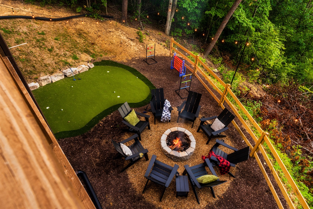 Backyard with fire pit, mini golf, string lights  and games