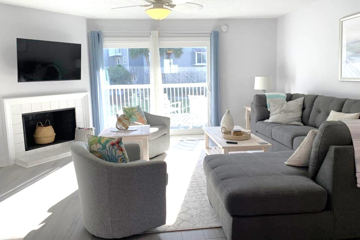 You'll spend more evenings here than you expect &mdash; deep sectional, Smart TV, natural light pouring in, and the deck just a step away.