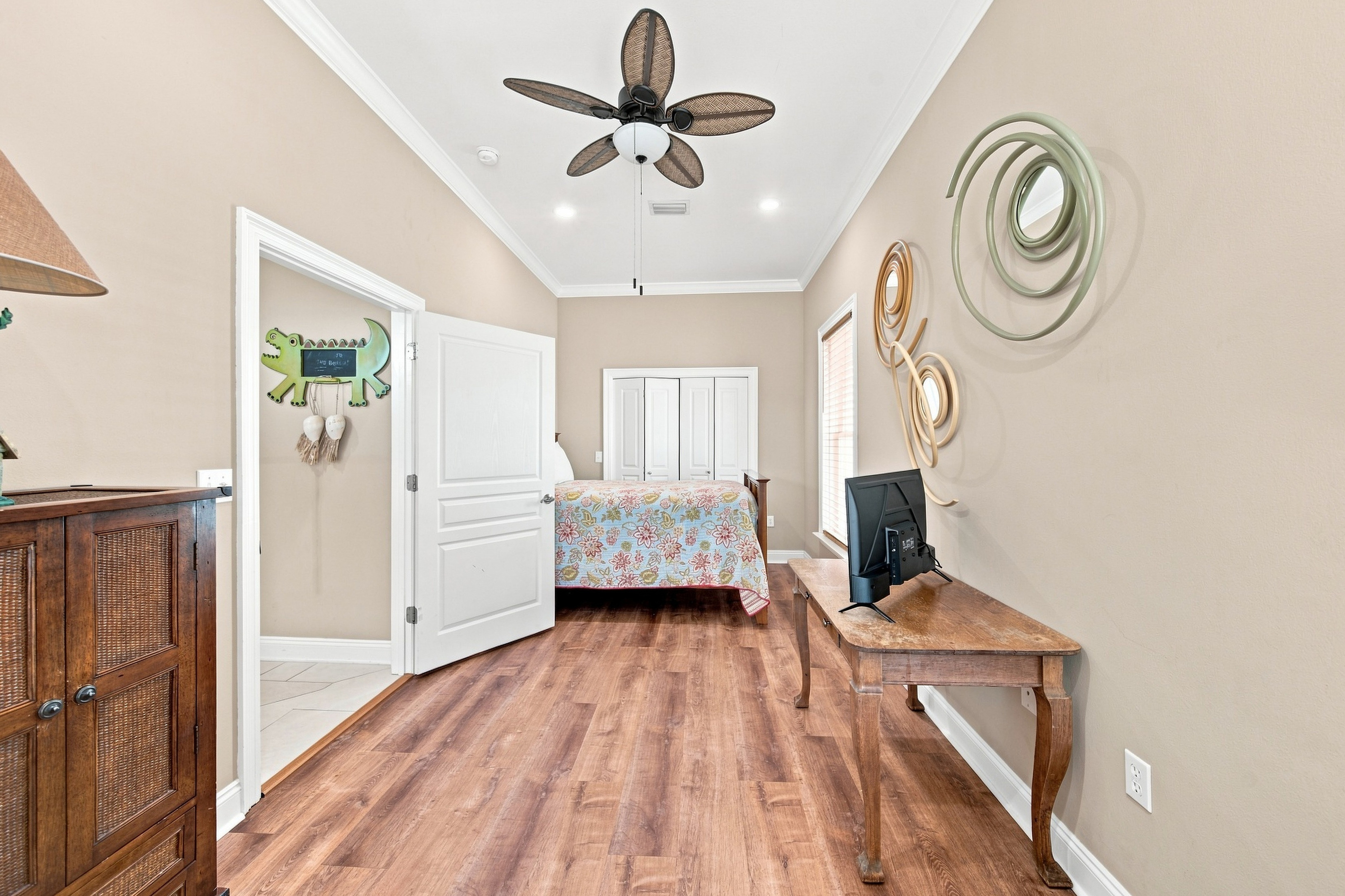 Bright bedroom with a ceiling fan and hardwood floors