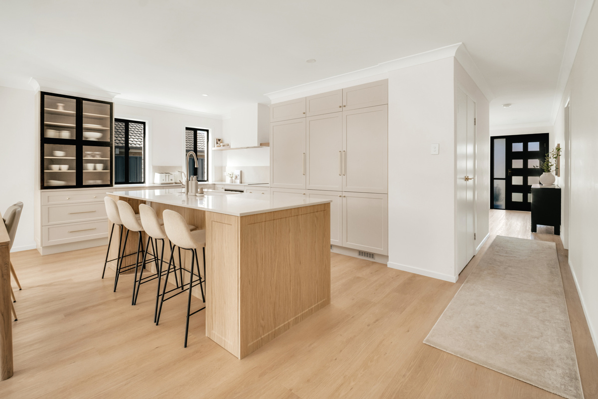 The kitchen island adds broad bench space, storage, an integrated sink and easy flow into the open-plan living area.