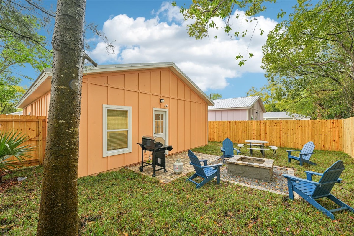 Outdoor area has a stone patio, stone fire pit, 4 adirondak-style chairs, and an 8-seat picnic table, with a fully fenced, private backyard.