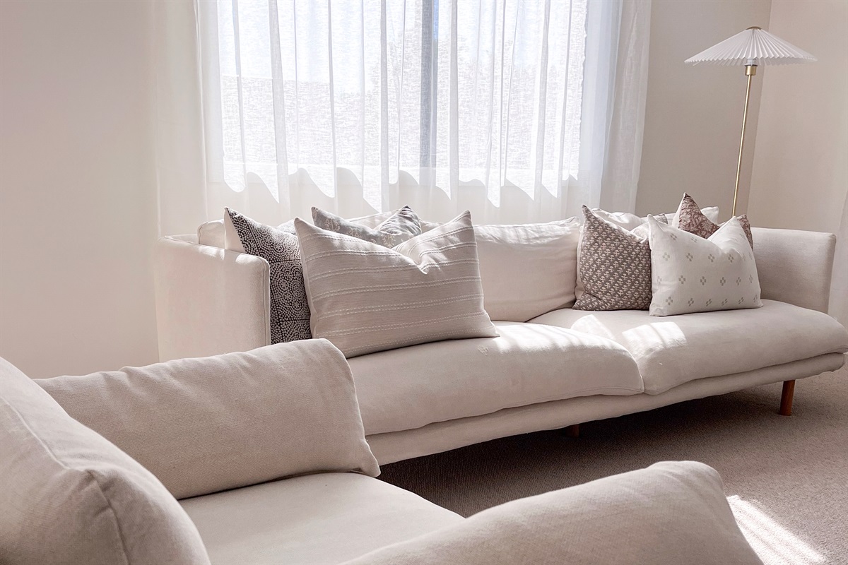 Two soft sofas provide seating for eight, giving the front lounge an easy sitting area beside the filtered window light.