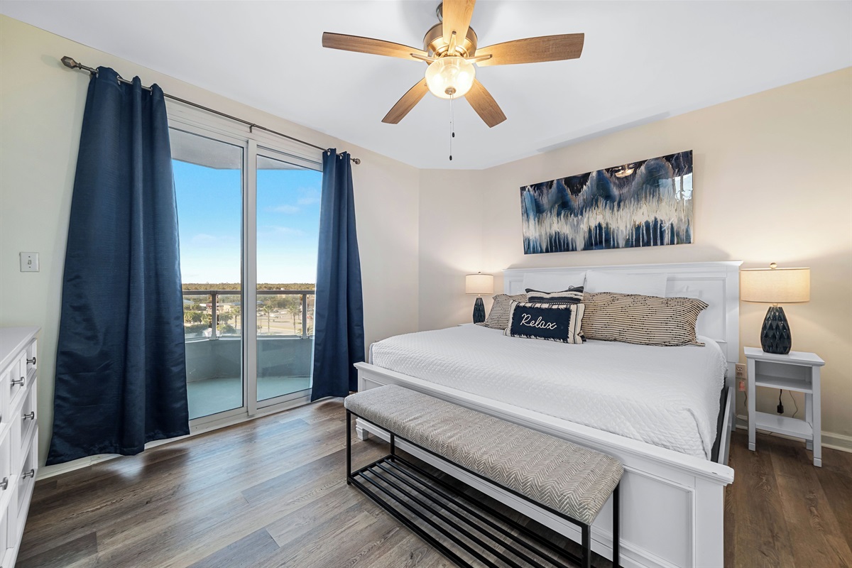 Primary bedroom with king bed, ceiling fan and direct balcony access! 