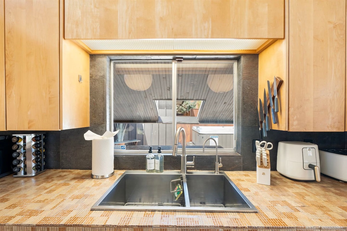 Clean and modern double sink station with sleek fixtures, warm wood cabinetry, and fully equipped countertops for everyday convenience.