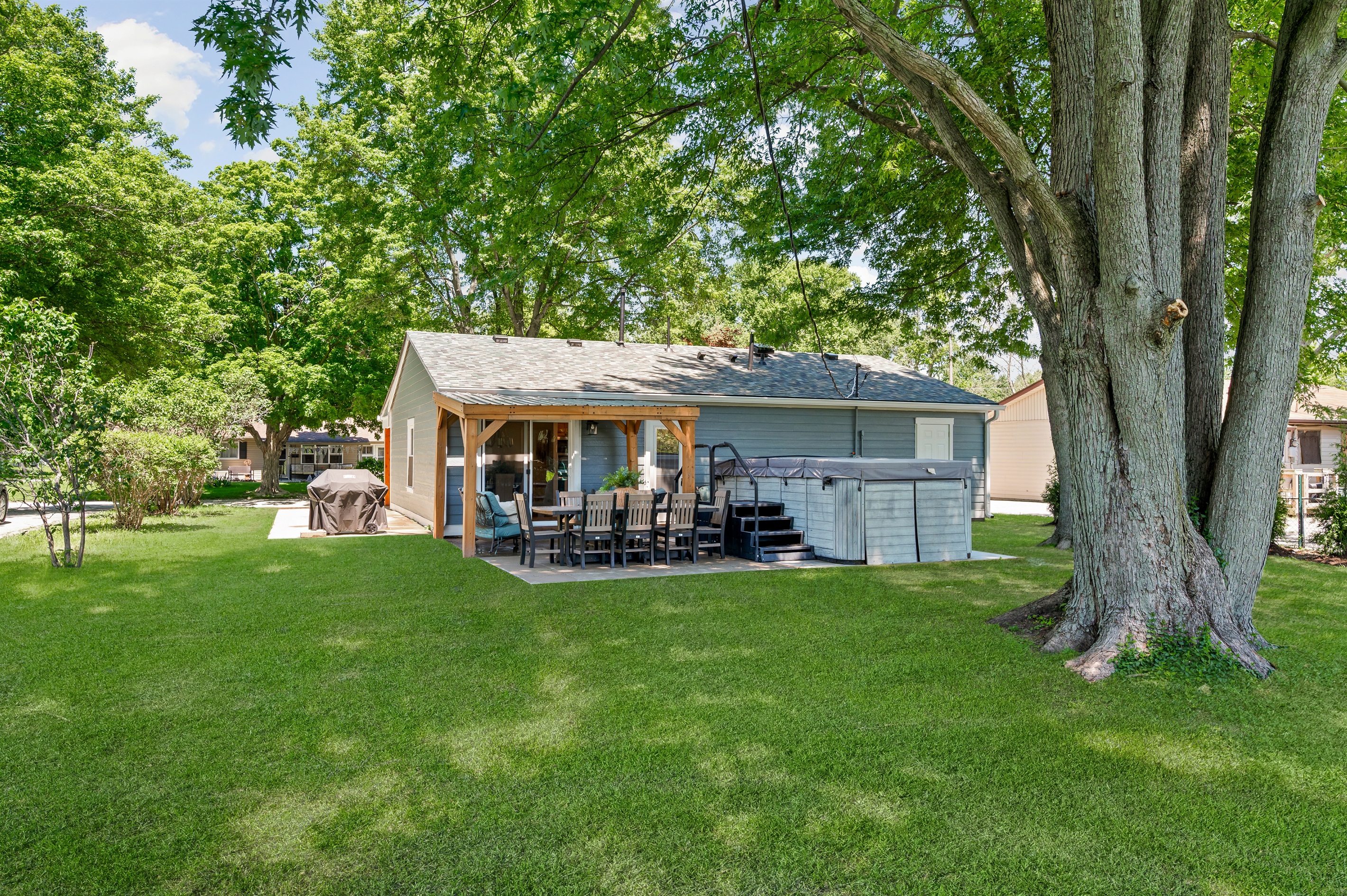 Enjoy the backyard oasis featuring a 14ft swim spa, outdoor dining for 8, grill, and comfortable seating area perfect for relaxing and spending time together.