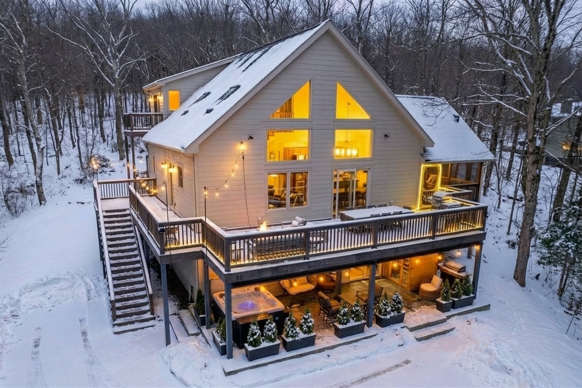 Snowy mountain retreat with hot tub, sauna & wraparound decks—warm lights, forest views, and cozy interiors make this the perfect Wintergreen ski-season escape.