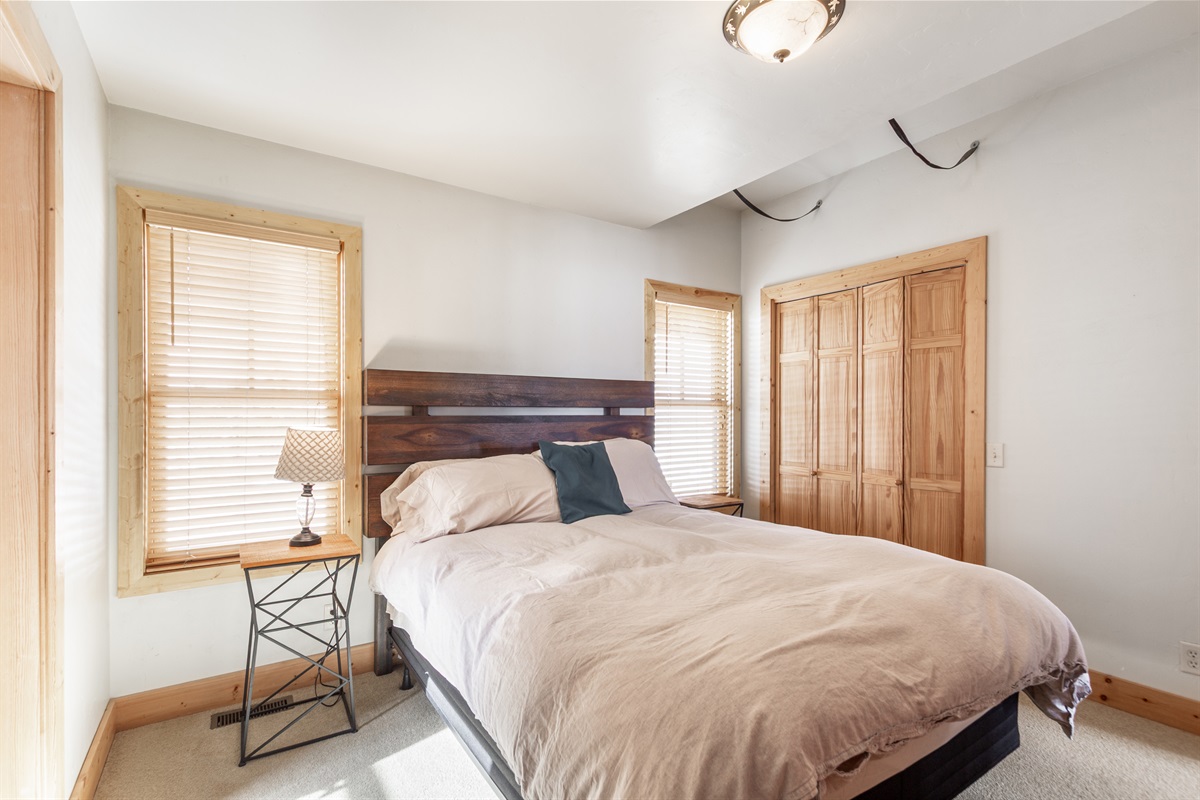 The second bedroom has beautiful views from the windows. The comfortable queen bed is the perfect place to rest after an adventurous day.