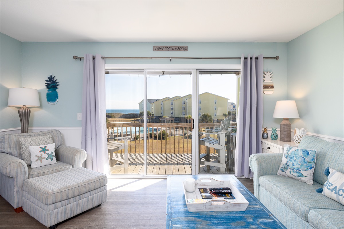 Living room with direct balcony access and peaceful ocean views